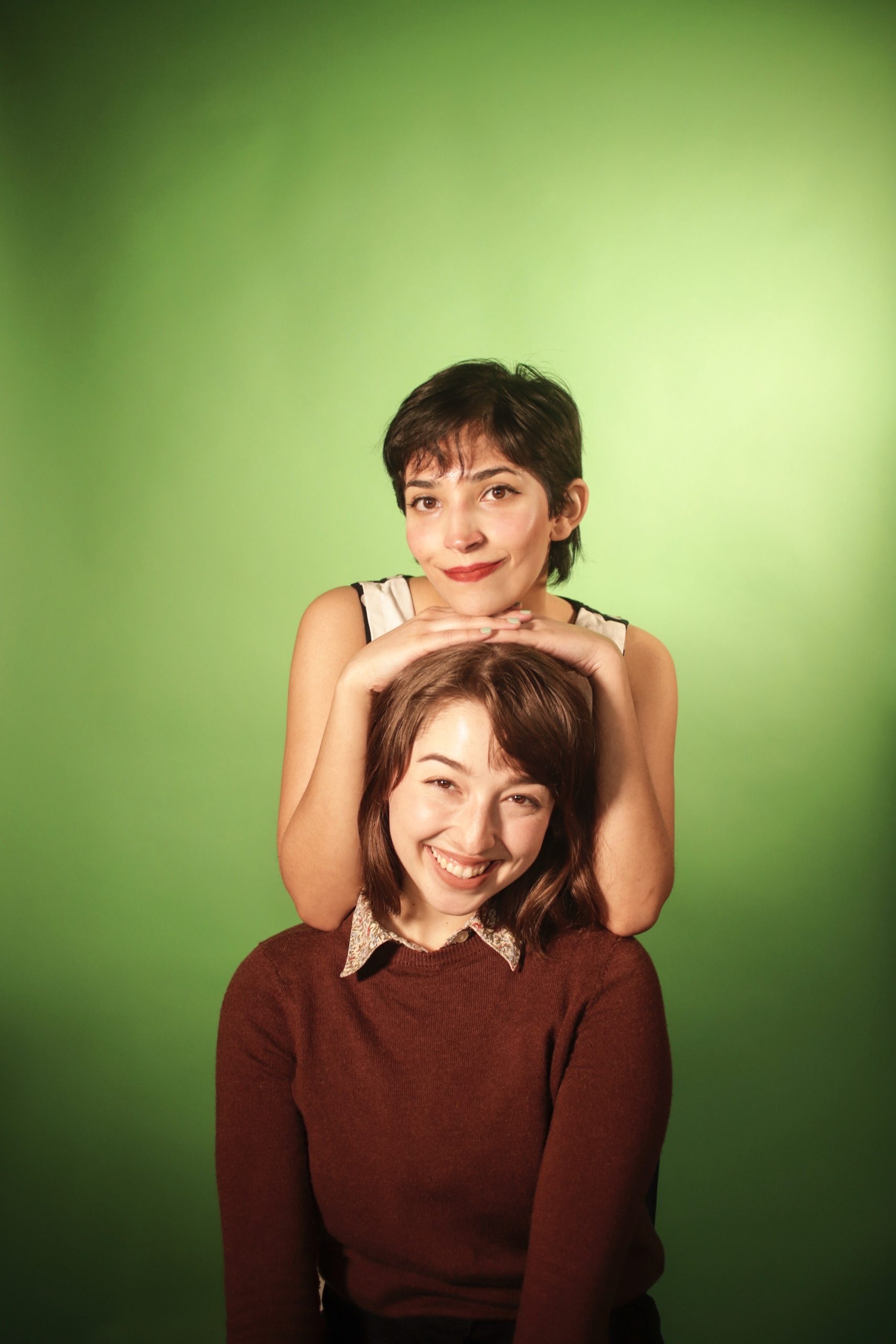 Tinu Thomas and Haley Butler pose with a green background