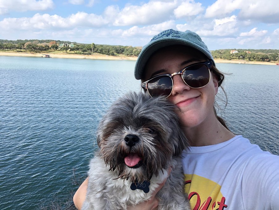 Katey Outka poses at a lake with her dog, Oso